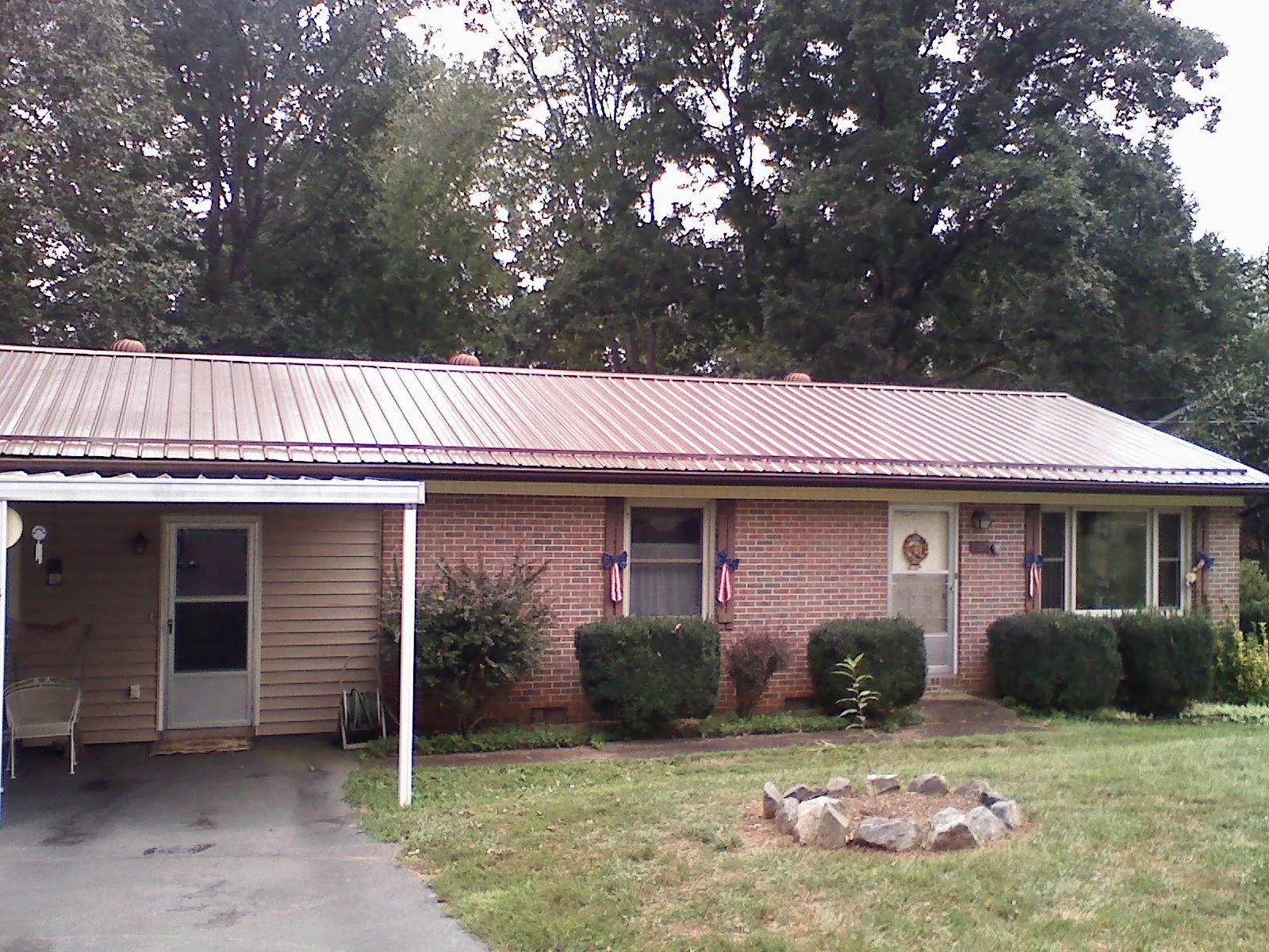 Bronze metal roof and carport on a brick ranch home — Roof Repair work by our crew in Ruby